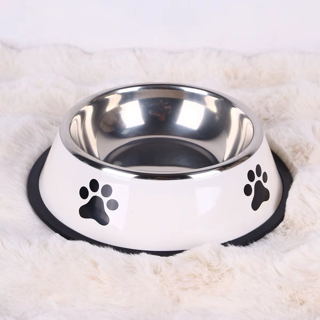 White stainless steel dog bowl with paw prints on a soft white rug